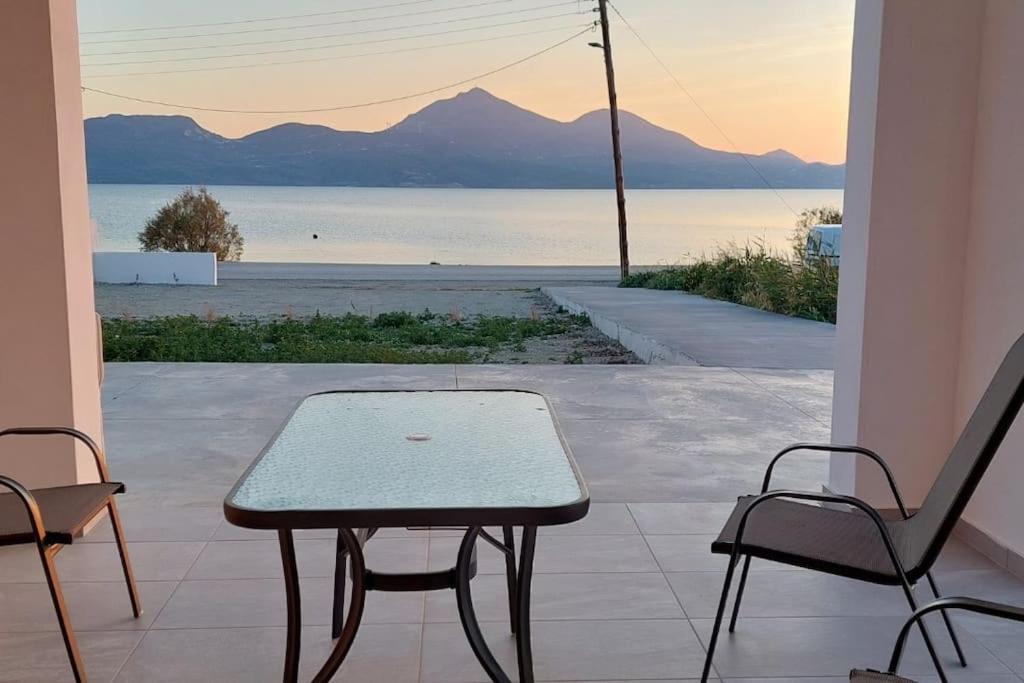 a table and chairs on a patio with a view of the water at Bay-dream 3 in Adamantas