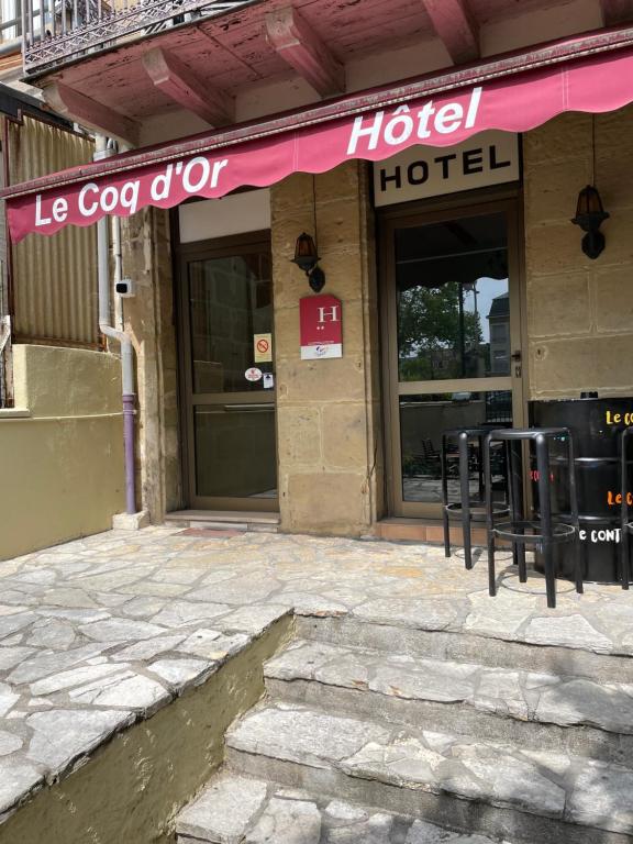 hotel z różową markizą na budynku w obiekcie Le Coq d'Or w mieście Brive-la-Gaillarde