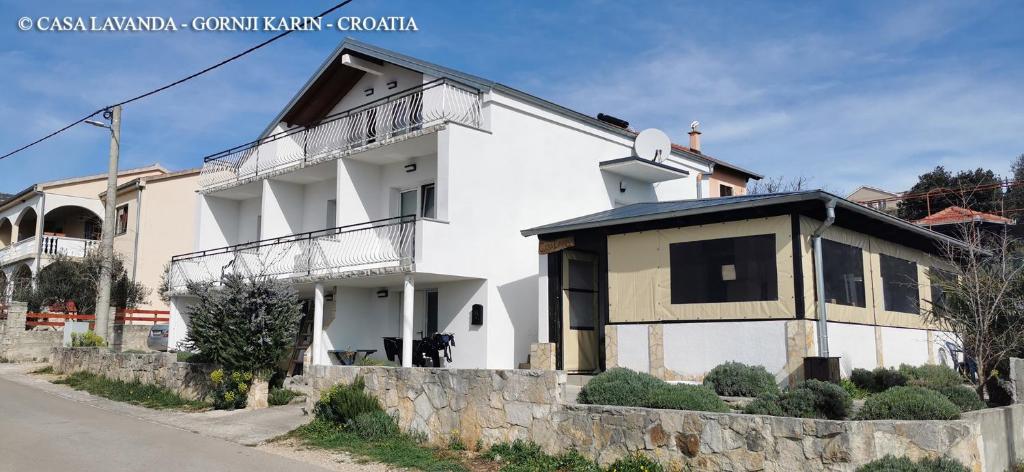 uma casa branca com uma varanda numa rua em Casa Lavanda 2 - Karin Gornji em Gornji Karin