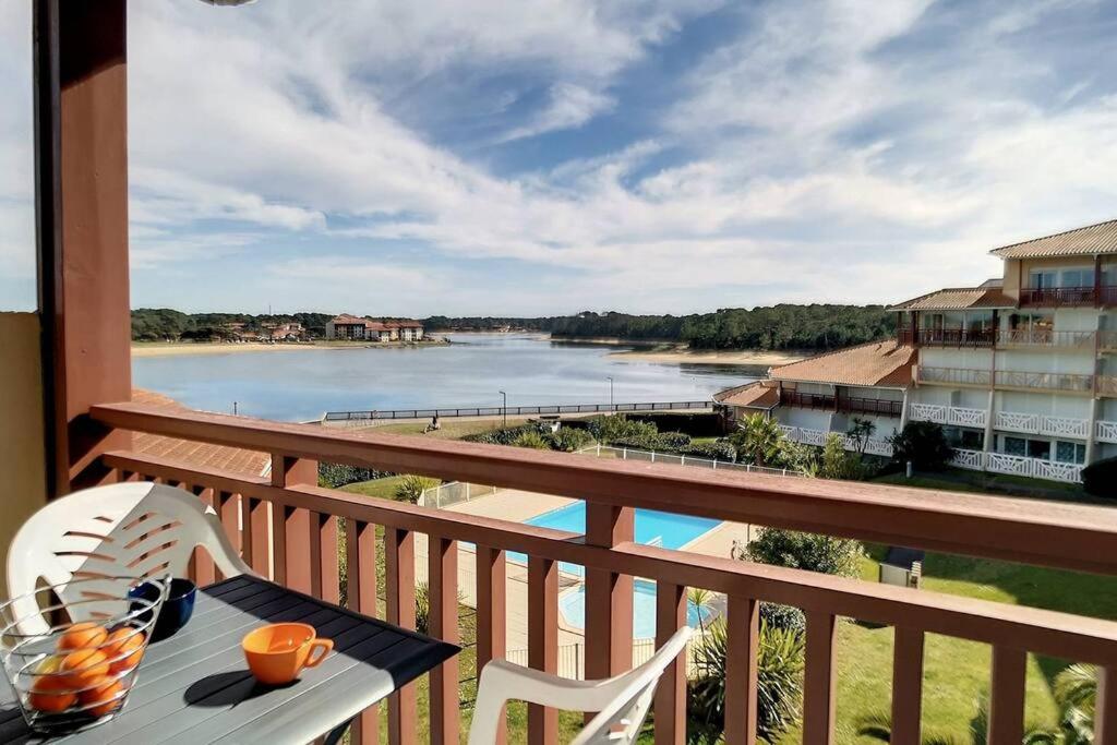 d'un balcon avec une table et une vue sur la rivière. dans l'établissement V-Marin 05-Vieux Boucau appartement 4 personnes avec vue sur lac marin dans résidence avec piscine, à Vieux-Boucau-les-Bains