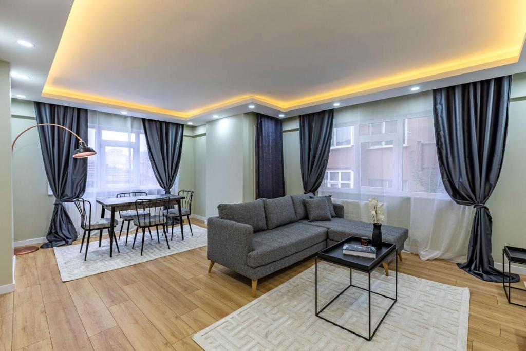 ein Wohnzimmer mit einem Sofa und einem Tisch in der Unterkunft Modern and Well Designed Apartment Near Public Transportation in Maltepe in Istanbul
