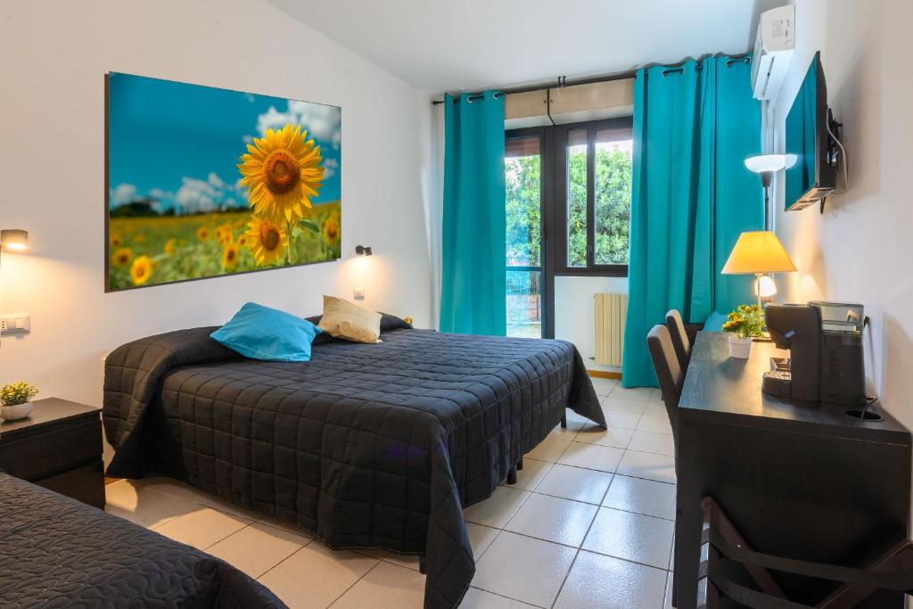 een hotelkamer met een bed, een bureau en een raam bij Hotel Anna Siena Nord in Siena