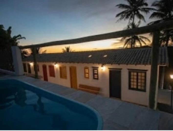 a house with a swimming pool in front of it at Pousada Vila Sol Maior in Guarapari