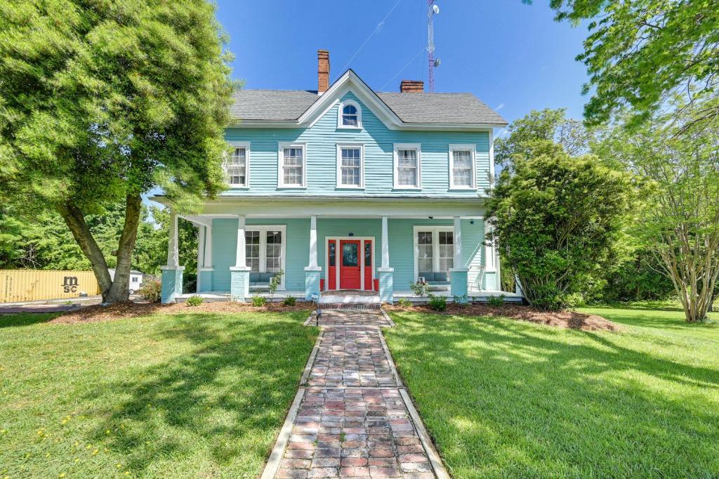 uma casa azul com uma porta vermelha num relvado em Historic Home with Yard Near High Point University em High Point