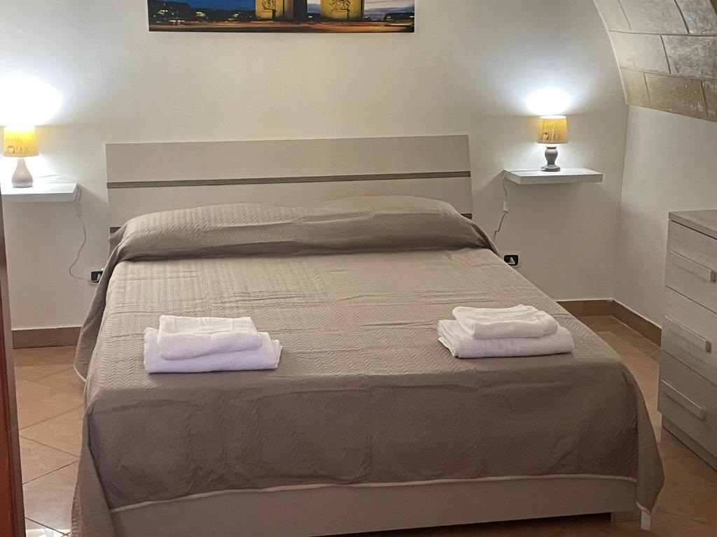 1 dormitorio con 1 cama con 2 toallas en La Maison Del Castello, en Barletta