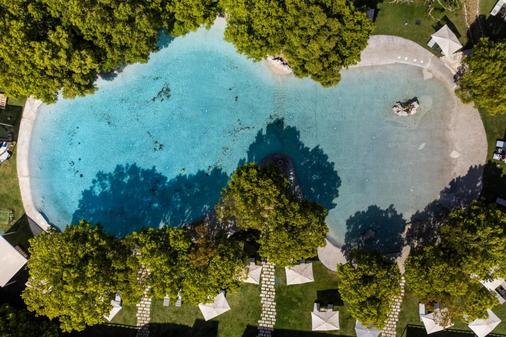 an aerial view of a large blue lake with trees at Furnirussi Tenuta in Carpignano Salentino