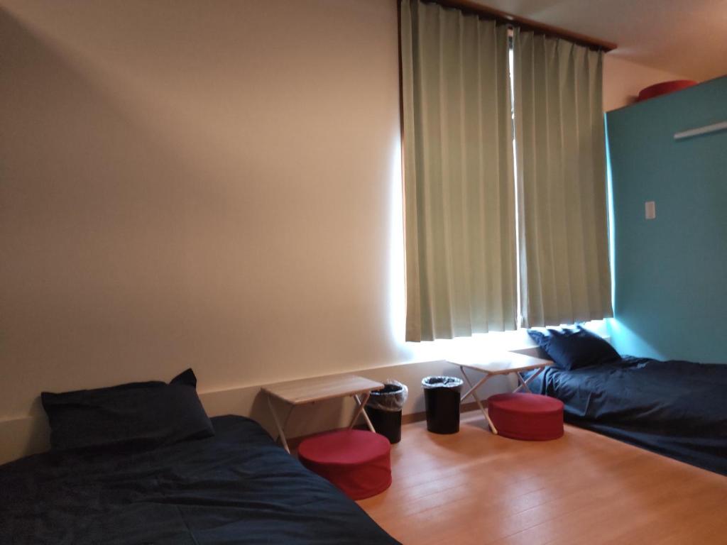 Yunotsu Fureaikan - Vacation STAY 01037v في Oda: غرفة نوم مع سرير ونافذة مع المقاعد الحمراء
