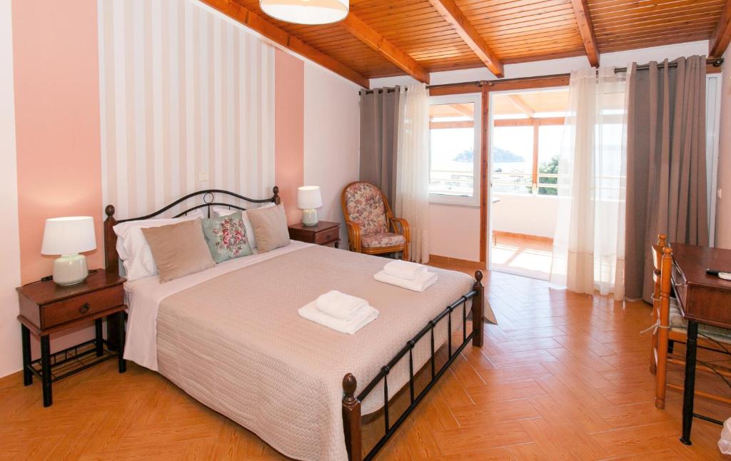 a bedroom with a bed with two lamps and a desk at Hotel Thetis in Tolo