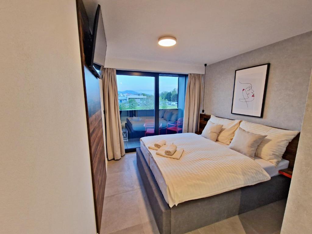 ein Schlafzimmer mit einem Bett und einem großen Fenster in der Unterkunft Penzion San Martin in Martin
