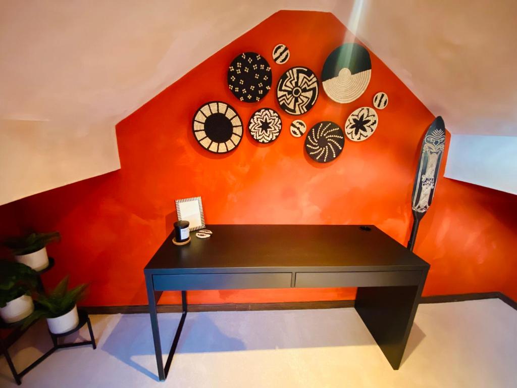 a black desk in a room with a red wall at Beautiful Boho in Bridgend in Bridgend