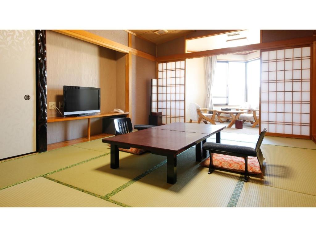 een woonkamer met een tafel en een televisie bij Reviews of Resort Hills Toyohama Soranokaze - Vacation STAY 78008v in Toba