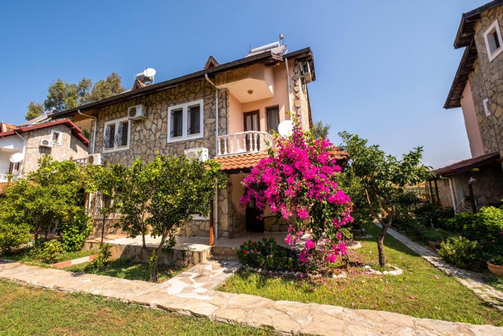 a house with pink flowers in front of it at Wonderful Home Close to Beach in Fethiye in Fethiye