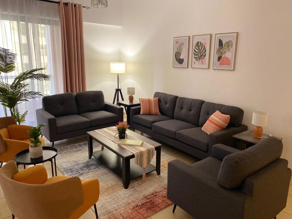 Grays Hostel By Haly في دبي: غرفة معيشة بها كنب وكراسي وطاولة