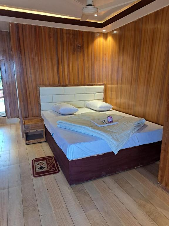 a bedroom with a bed with a wooden wall at Sandy Beach Resort & Restaurant in Cox's Bazar