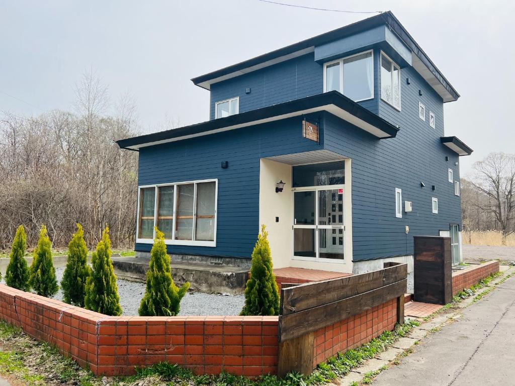 una casa azul con una pared de ladrillo en Living house Midorinonakano Nabeyasanchi - Vacation STAY 72360v, en Ōnuma