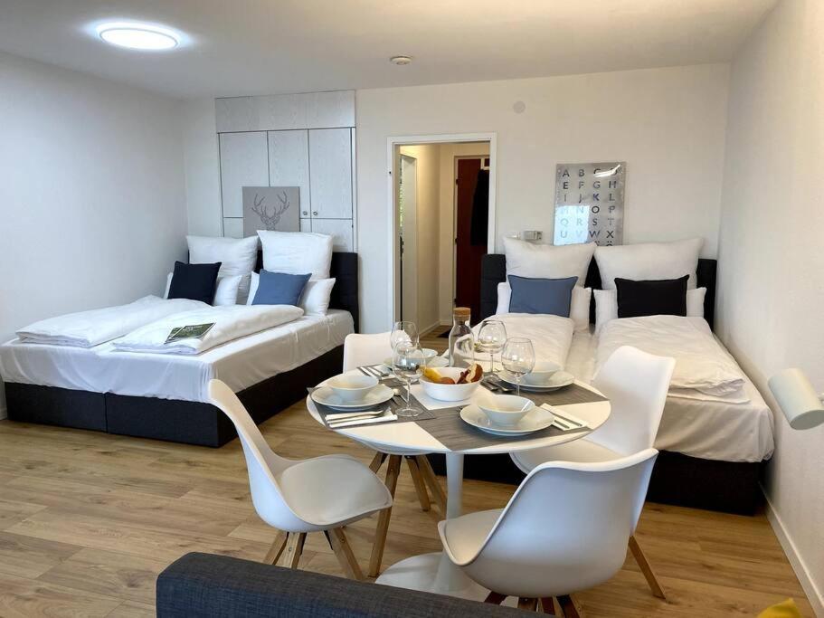 a room with two beds and a table and chairs at 1-Zimmerapartment mit Burgblick in Bad Liebenzell