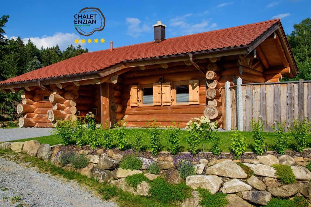 a log cabin with a fence in front of it at Chalet Enzian Bayerwald in Arnbruck