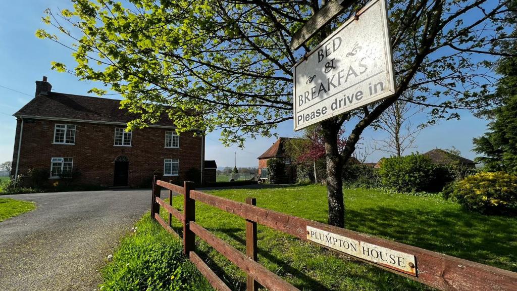 un cartel en una valla delante de una casa en Plumpton House, en Ashford