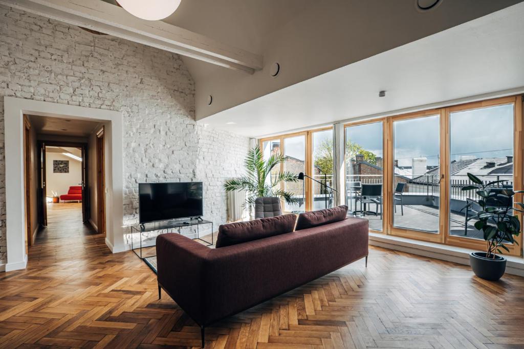 a living room with a couch and a tv at Constantine Apartments in Riga