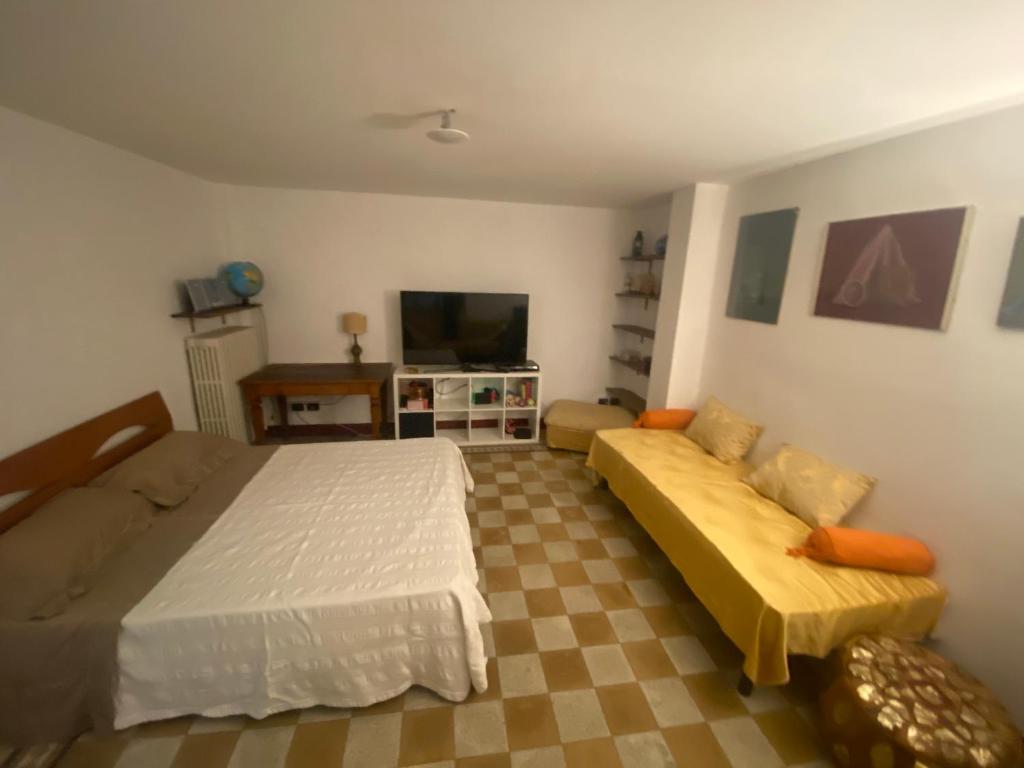 a bedroom with a bed and a couch and a tv at I nespoli in Imola