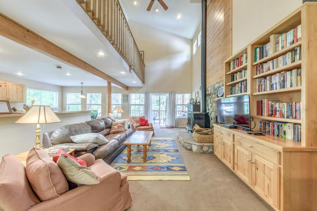 ein Wohnzimmer mit einem Sofa und einem TV in der Unterkunft Scenic Riverside Cabin in Ruidoso with Deck and Grill! in Ruidoso