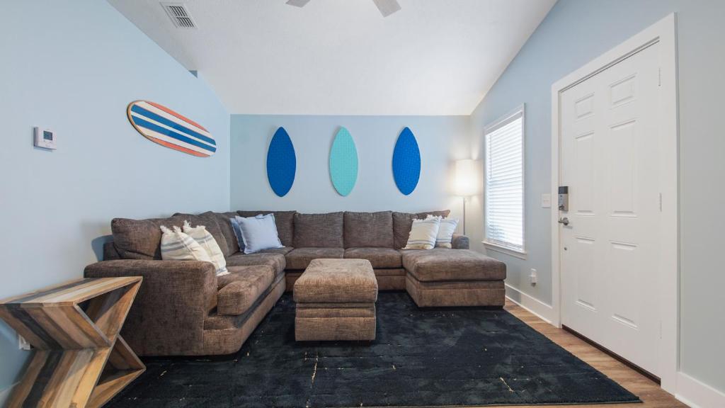 salon z brązową kanapą i niebieskimi ścianami w obiekcie Red Neptune by Nautical Properties w mieście Panama City Beach