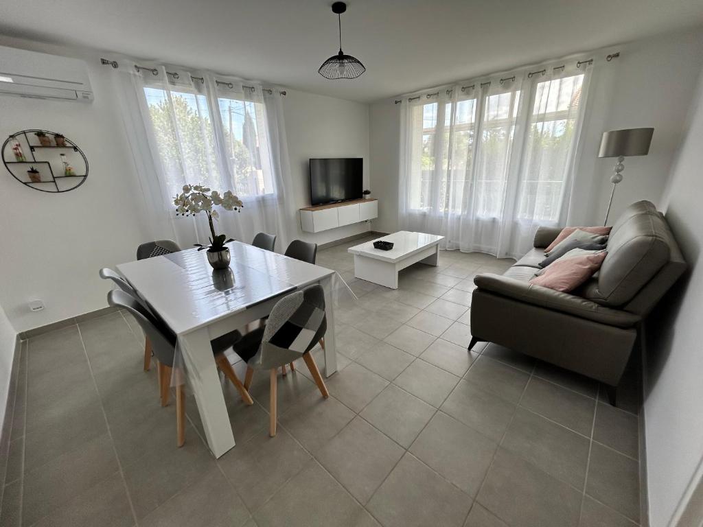 L'Entre Deux Rêves في Beaumont-lès-Valence: غرفة معيشة مع أريكة وطاولة