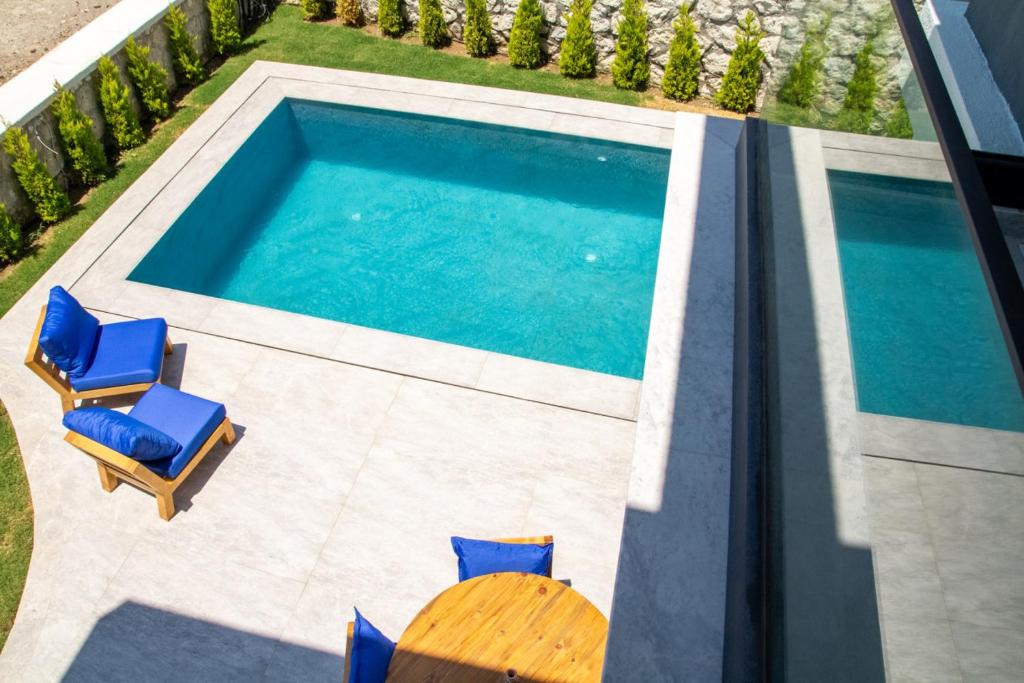 una vista sul tetto di una piscina con sedie e tavolo di Lovely Villa with Private Pool in Alacati Cesme ad Alaçatı