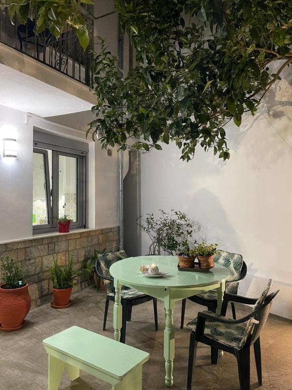 een tafel en stoelen in een kamer met planten bij Nina’s Garden in Loutrákion