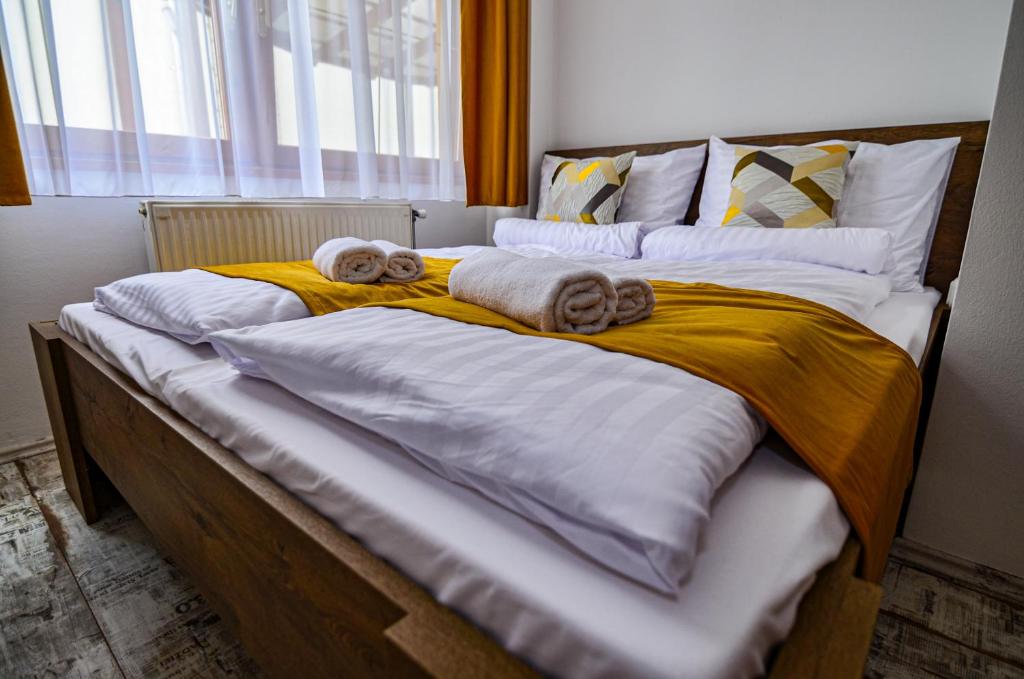 a large bed with towels and pillows on it at Kossuth Vendégház in Tolna
