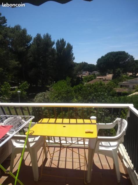 une table et des chaises jaunes sur un balcon dans l'établissement MER & LAC SOLEIL, à La Grande Motte