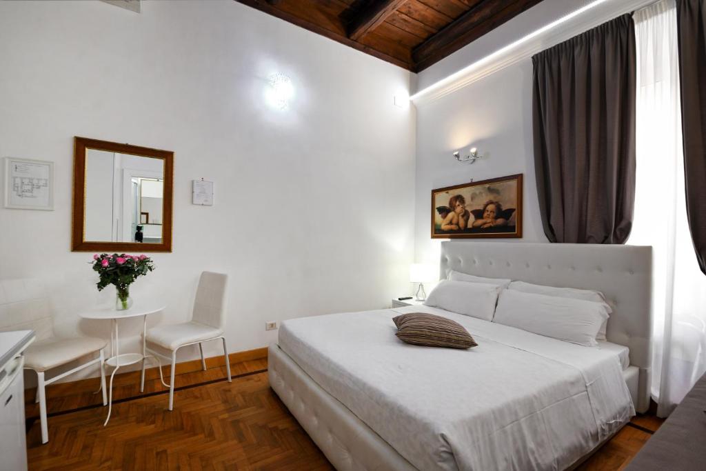 ein weißes Schlafzimmer mit einem Bett, einem Tisch und Stühlen in der Unterkunft Roman Nights in Rom