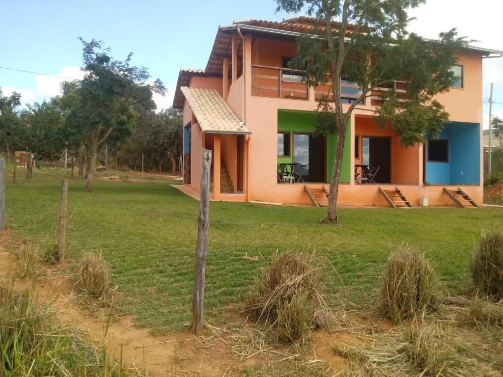 a house in the middle of a field at Pouso dos Sonhos Suítes Lapinha da Serra in Santana do Riacho