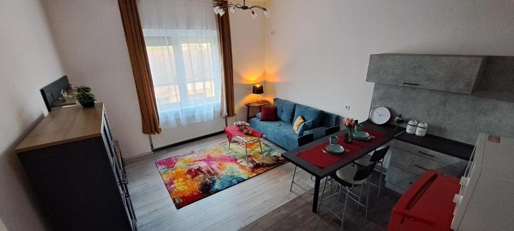 Napraforgó apartman في سيجد: غرفة معيشة مع أريكة زرقاء وطاولة
