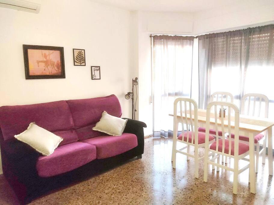 a living room with a purple couch and a table at Apartamento con vistas al castillo in Sagunto
