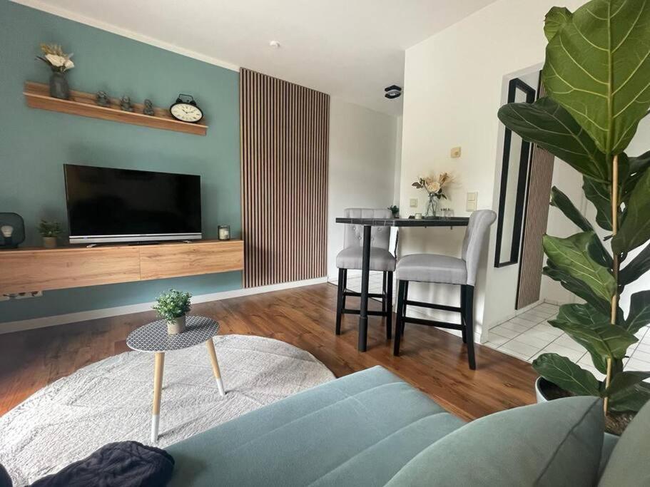 a living room with a blue couch and a table at Modernes Apartment in Chemnitz in Chemnitz