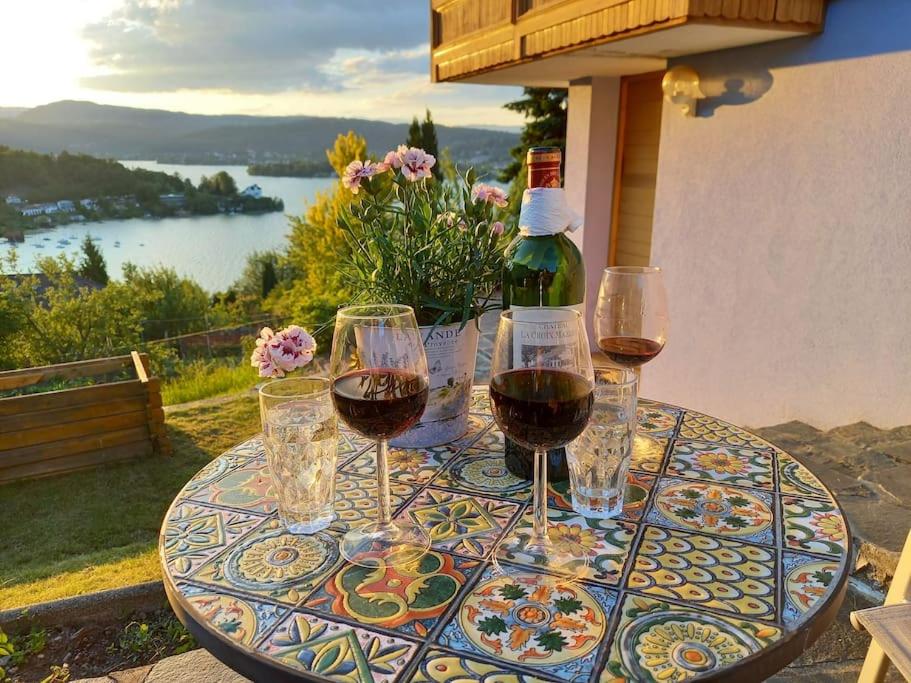 una mesa con copas de vino y una botella de vino en Haus Sonnenhang +Seeblick+Pool en Reifnitz