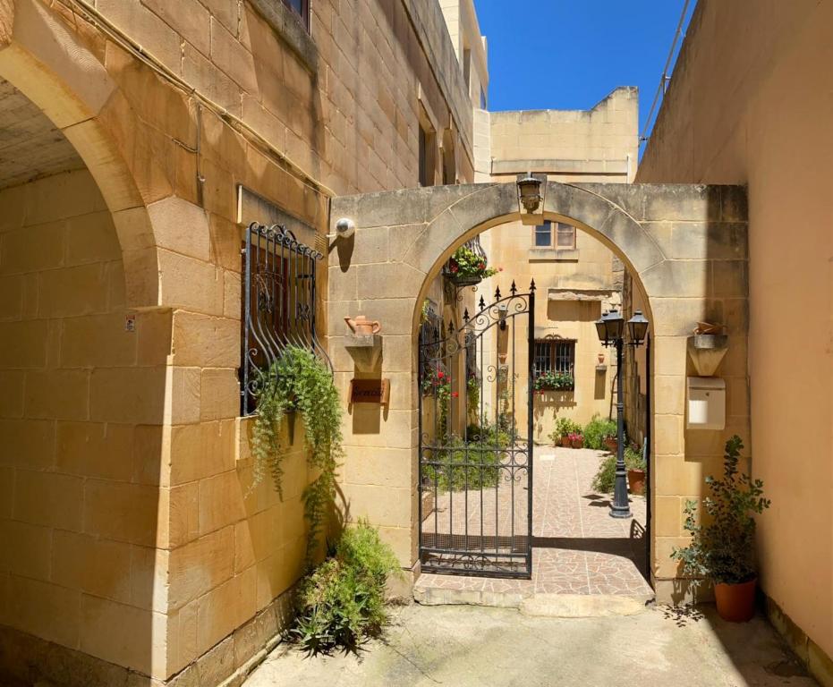 una entrada a un callejón con puerta de hierro en Villa Serenita, en Xagħra