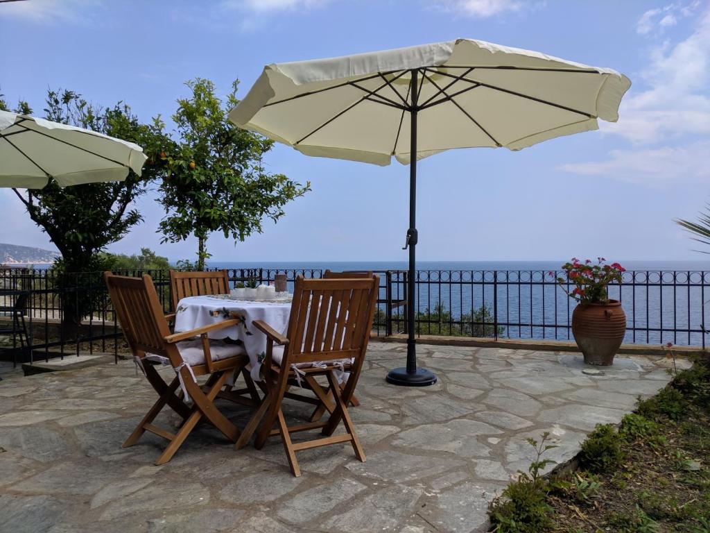 mesa y 2 sillas con sombrilla en Zennova #3 Mount Athos & Sea View, en Pyrgadikia