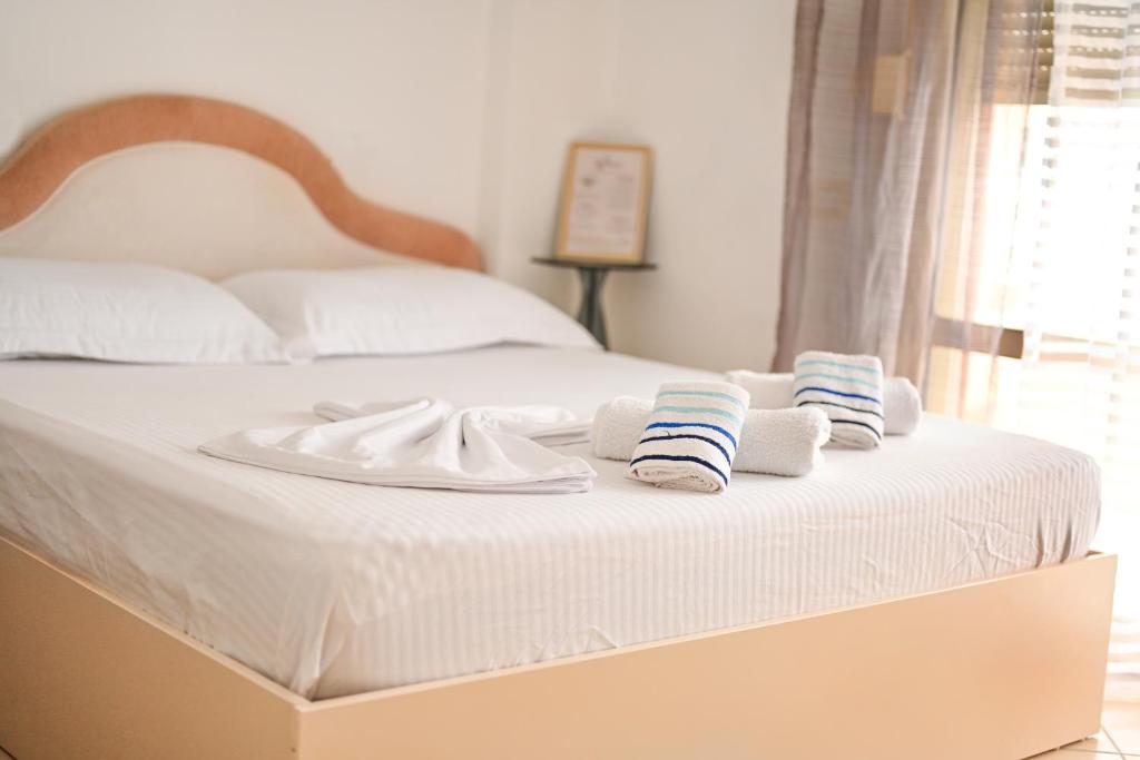 un letto bianco con sopra asciugamani di COASTAL RETREAT - Beach Apartment Vlore a Vlorë
