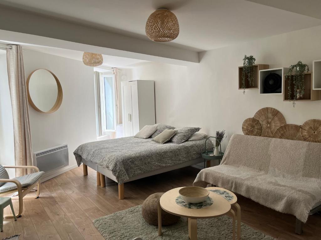 salon z kanapą i stołem w obiekcie Studio Hyères -Rue piétonne Climatisation lit 160 tout équipé - Sabrina w Hyères