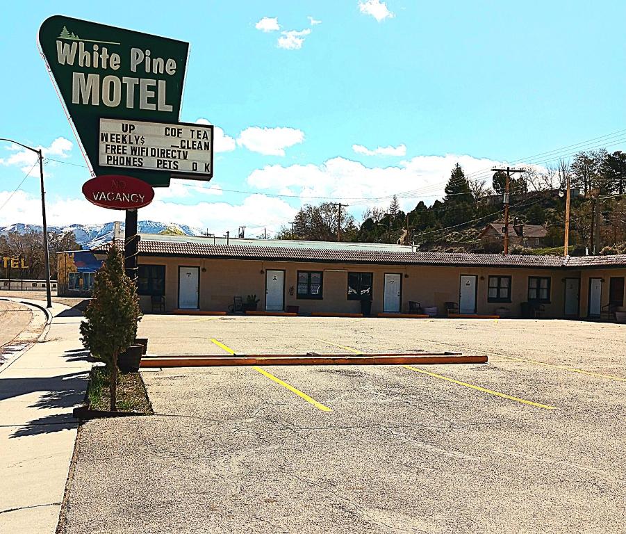 White Pine Motel في إيلي: علامة لموتيل الصنوبر الأبيض في موقف للسيارات