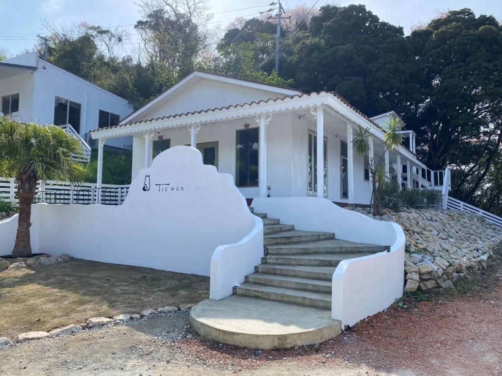 une maison blanche avec des escaliers en face de celle-ci dans l'établissement Tiz wan kudashi - Vacation STAY 27480v, à Awaji