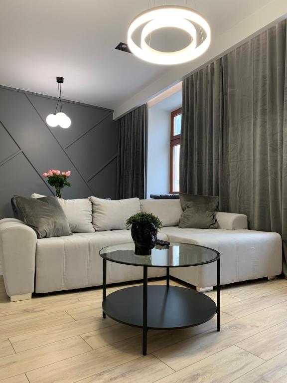 a living room with a white couch and a table at ALLURE PREMIUM APARTMENT in Lublin