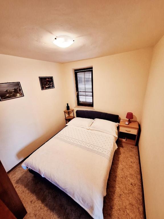 1 dormitorio con 1 cama blanca grande y ventana en Maria´s Haus en Novigrad Istria