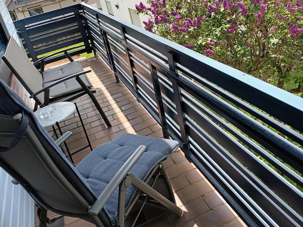 a rocking chair sitting on a balcony with flowers at Büdingen-Ferienwohnung Bausch in Büdingen