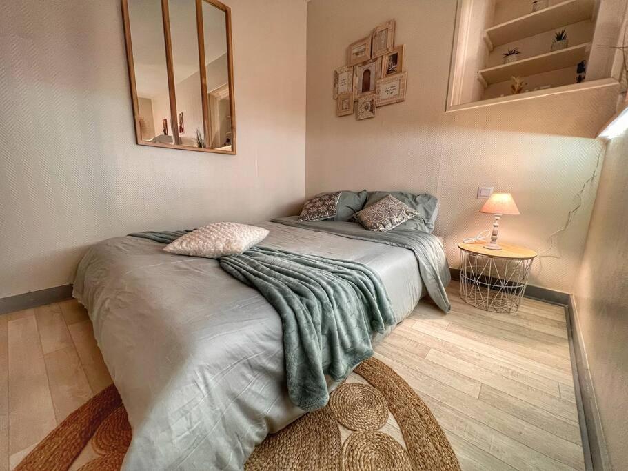 sypialnia z łóżkiem z kocem i lustrem w obiekcie Studio ZEN hyper centre Cognac w mieście Cognac