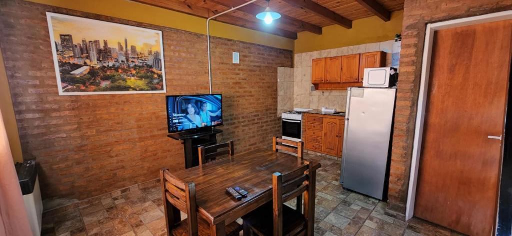 Antartida Apart Zapala في زابالا: مطبخ مع طاولة خشبية وثلاجة