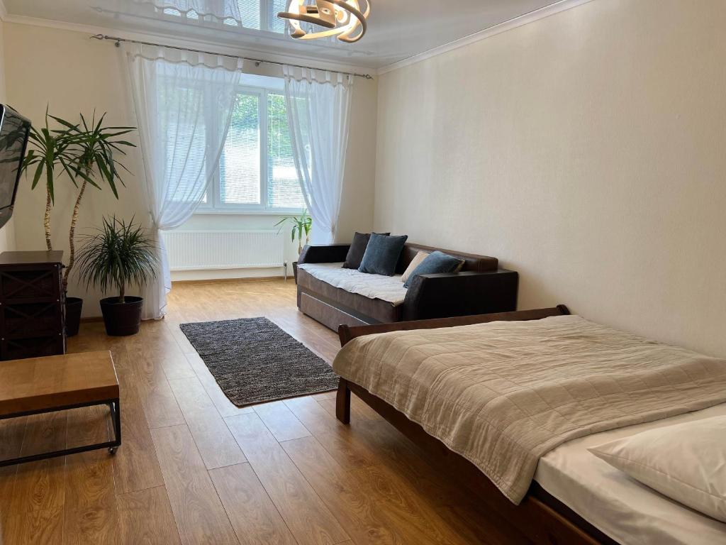 - un salon avec un lit et un canapé dans l'établissement New Apartment "Family Estate", à Kamianets-Podilsky