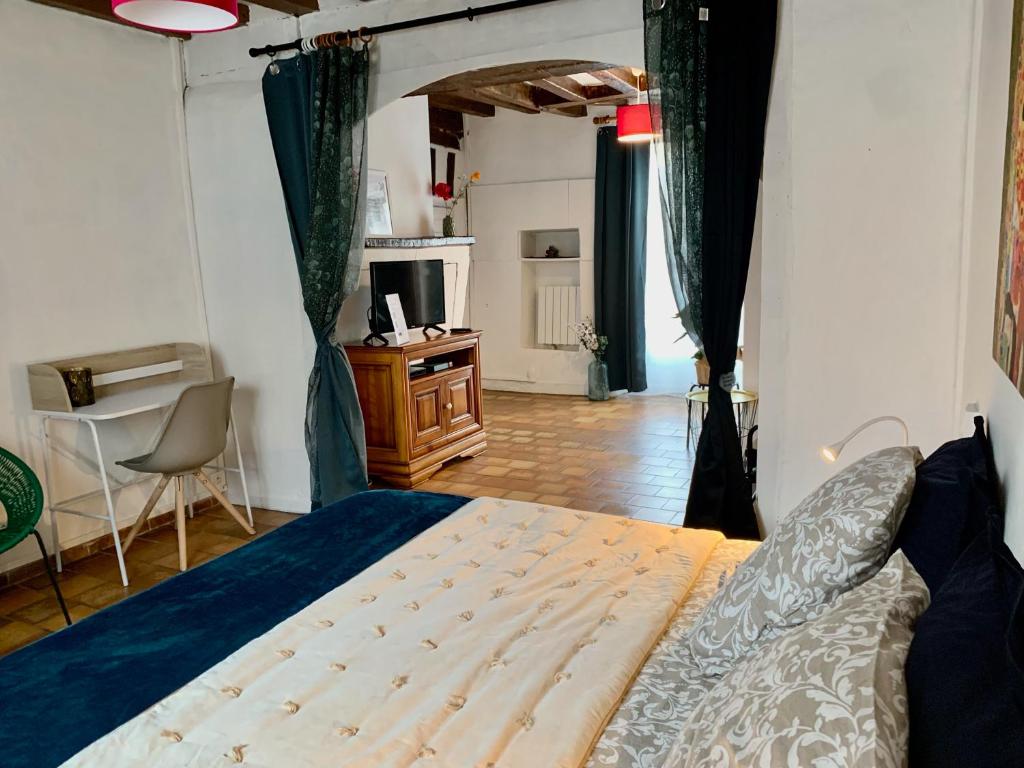 a bedroom with a bed and a desk in it at Les marches du château - Gîte centre de Nogent-le-Rotrou in Nogent-le-Rotrou